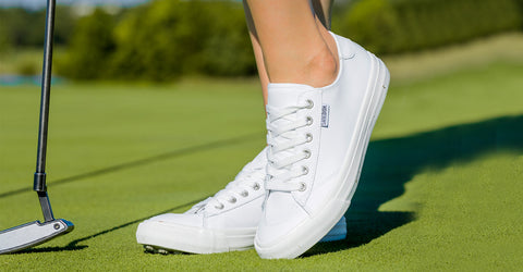 close up of womens WhiteWomen's Tops & Long T-Shirts,Sustainable Womenswear Shop traveler spikeless shoe while standing on a golf course 